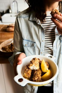 a woman holding a bowl filled with food