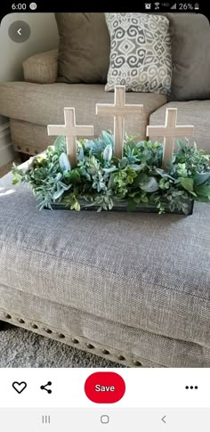 a living room with a couch, coffee table and cross decoration on the top of it