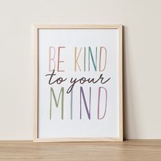 a framed print with the words be kind to your mind in rainbow colors on it