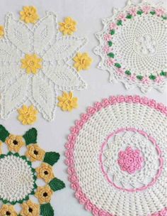 crocheted doily with flowers and leaves on the top one is pink, white, yellow and green