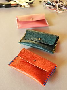 three different colored wallets sitting on top of a table