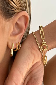 Style an everyday gold ear stack with varying hoop earrings and huggie earrings. Mix and match solid gold and shimmer earrings for a dynamic look. Complement the jewelry look with a gold bracelet stack. Styling tip: Add dainty gold rings to the jewelry look to complete the style. Gold Hoop Stack Earrings, Gold Earring Stack Ideas, Hailey Bieber Ring, Stacked Hoop Earrings, Jewelry Matching, Ear Stack, Earring Gold