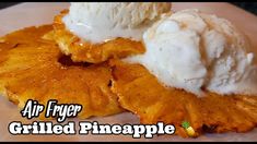 an air fryer grilled pineapple is topped with ice cream and sits on a plate