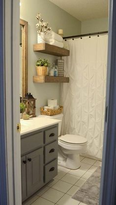 a white toilet sitting next to a bathroom sink under a shower curtain in a bathroom