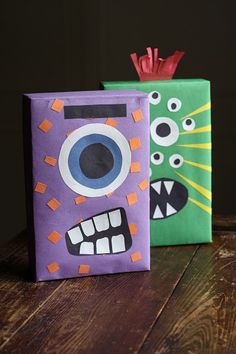 two paper bags decorated like monsters with flowers in the middle one is purple and the other is green