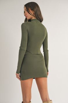 Make a statement in our Olive Rib Mock Neck Mini and Skirt Set. This sleek and stylish ensemble is sure to turn heads with its fitted ribbed knit fabric and modern silhouette. Perfect for a night out, you'll look and feel confident wearing this timeless fashion-forward set. Fabric & fit: 70% VISCOSE 30% NYLON Model is wearing size Small. Fitted Solid Mini Skirt For Fall, Fitted Elastane Mini Skirt For Fall, Fitted Trendy Mini Skirt, Sleek Fitted Mini Skirt For Fall, Trendy Fitted Elastane Mini Skirt, Fitted Mini Skirt For Winter Night Out, Fitted Mini Skirt For Night Out In Winter, Fall Bodycon Top, Casual Fitted Ribbed Mini Skirt