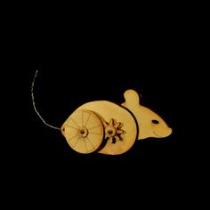 a wooden mouse with wheels attached to it's back end, on a black background