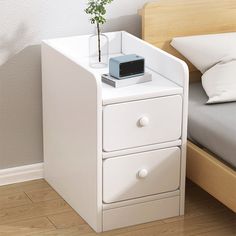 a white nightstand with a plant on top