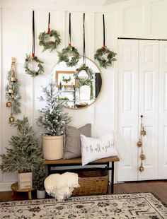 a living room decorated for christmas with wreaths on the wall and other holiday decorations