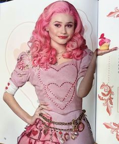 a woman with pink hair is holding a cupcake