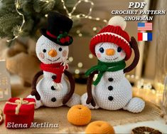 two crocheted snowmen sitting next to each other with presents in front of them