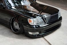 a black car parked on top of a sidewalk