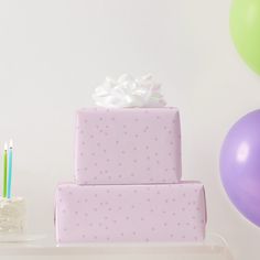 a three tiered cake sitting on top of a table next to balloons and candles