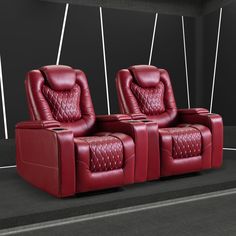 two red leather recliners sitting next to each other on a black floor with white lines in the background