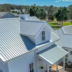 an aerial view of a white house with metal roofing