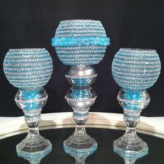 three blue glass candlesticks sitting on top of a table