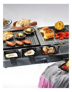 an electric griddle grill with various foods cooking on the top and side burners