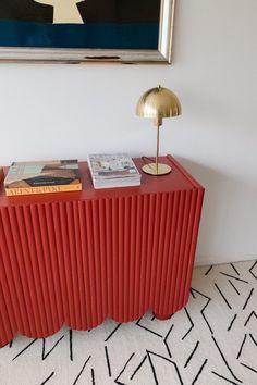 a red sideboard with books on it in a room