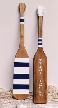 two wooden paddles sitting next to each other