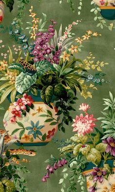 a green wallpaper with colorful flowers and birds on the top, in front of an ornate potted plant