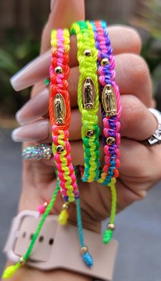 a person holding three different colored bracelets