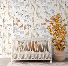 a baby crib in front of a wallpaper with giraffes and zebras