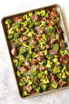 broccoli florets and meat in a baking pan on a counter top