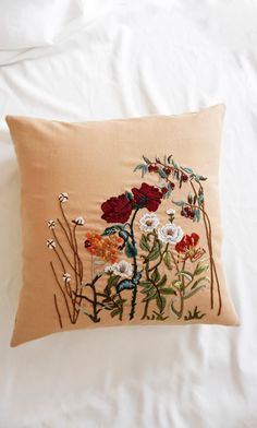 an embroidered pillow with flowers on it