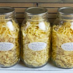 three jars filled with shredded cheese sitting on top of a shelf next to each other