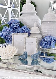 blue hydrangeas and white vases on a mirrored table