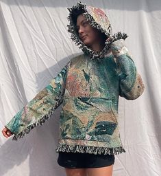 This is a one of a kind blanket / tapestry hoodie with my art. The fabric is woven 95% cotton and 5% poly blend to give the fabric a little more flexibility. Fabric is printed in America and the hoodies are stitched by me.  They are very high quality, unique, wearable art. This light green one measures 21 1/2 inches across and 25 1/2 inches from highest point of the shoulder to bottom (before fringe). Model is 5'9 and size 4/6 for reference. This one is a medium. Mediums are the smallest size I make. For longevity of the garment, it is best to spot clean/hand wash, but you can machine wash them in cold water. Hang to dry. Message me for customs. Woven Tapestry Hoodie, Artistic Hooded Hoodie For Fall, Artistic Cotton Hooded Hoodie, Artistic Cotton Hoodie, Bohemian Cotton Hoodie For Festival, Bohemian Hooded Hoodie For Festivals, Bohemian Hoodie For Festivals, Bohemian Winter Festival Hoodie, Hippie Hooded Hoodie For Festivals