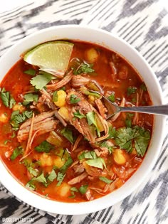 a white bowl filled with meat, beans and cilantro on top of a table