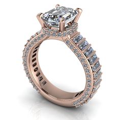 a rose gold engagement ring with an emerald center stone and side stones on the band