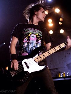 a young man playing an electric guitar on stage