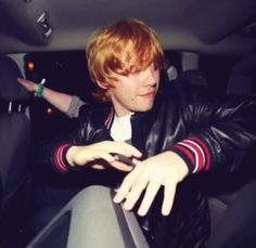 a young man sitting in the back seat of a car