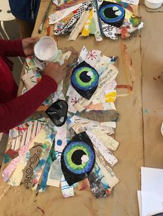 a woman is working on an art project with paper collages and eyeballs