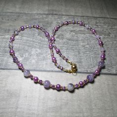 "Amethysts feature in this purple necklace. Running the length of this necklace are 4x2mm opaque/clear purple Czech Crystal beads. At each end of the necklace the Crystals alternate first with a 4mm Amethyst and then with a 6mm purple Glass pearl bead, after four Amethyst beads they are replaced with 6mm Amethysts. While in the centre of the necklace the Amethyst beads are 8mm. The necklace is approx 57.5mm (22.75\") long. All the metal work is Gold plated Stainless Steel including the magnetic clasp and the earwires on the free matching earrings. Necklace and earring come enclosed within a purple Silk bag. Amethyst helps to relax mind, body and spirit Amethyst is connected to the third eye, the centre of spirituality and intuition. Amethyst brings tranquillity, calm and peace of mind. It Spiritual Single Strand Purple Beaded Necklace, Purple Single Strand Beaded Necklace Gift, Gift Purple Single Strand Beaded Necklace, Purple Single Strand Beaded Necklace For Gift, Lavender Single Strand Round Bead Jewelry, Purple Single Strand Crystal Necklace Gift, Lavender Single Strand Jewelry With Round Beads, Adjustable Lavender Single Strand Necklace, Purple Necklace With Spacer Beads As Gift