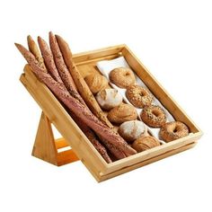 an assortment of breads and pastries in a wooden tray on a white background