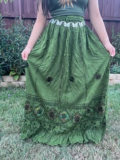 Introducing our Pari Vintage Vibe Green Embroidery Maxi Skirt, perfect for embracing those boho hippie vibes! This stunning skirt features a pleated border that adds a touch of elegance, while the maxi length offers a chic and comfortable fit. Crafted with fairycore fashion in mind, this skirt is ideal for creating enchanting cottage-core looks. Whether you're strolling along sandy shores or exploring hideaways, this skirt will ensure you're dressed to impress. Its flowing silhouette captures th Flowy Cotton Skirt With Floral Embroidery, Long Cotton Skirt With Embroidered Hem, Long Embroidered Cotton Skirt, Bohemian Flowy Skirt With Floral Embroidery, Flowy Cotton Skirt With Embroidery, Fitted Peasant Style Festival Skirt, Cotton Peasant Maxi Skirt For Festival, Peasant Style Cotton Maxi Skirt For Festival, Festival Tiered Skirt Dress With Lined Skirt