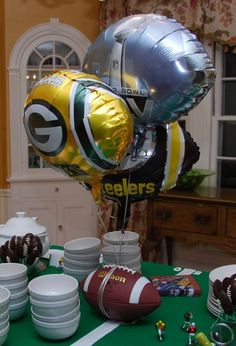 balloons, plates and footballs are on a table