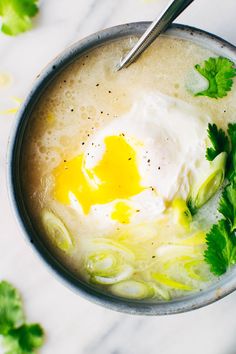 a bowl filled with soup and topped with an egg