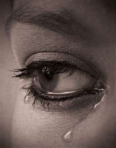 a woman's eye with water drops on the iris and her reflection in it