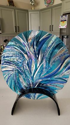 a blue glass plate sitting on top of a counter next to a refrigerator freezer