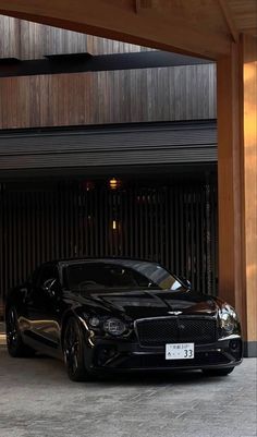 a black sports car parked in front of a garage