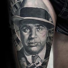 a man with a hat and tie on his arm is depicted in this tattoo design