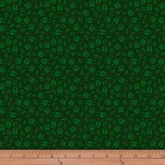 a ruler is next to a green wallpaper with leaves on it and the bottom half of