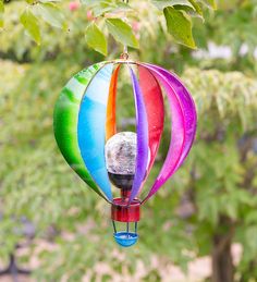 a multicolored hot air balloon hanging from a tree