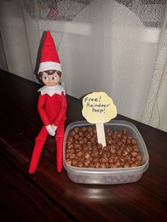 an elf is sitting next to a bowl of peanuts and a sign that says free reminder pop