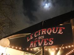 the sign for le cirque des reves is lit up at night time