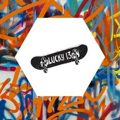 a skateboard that is sitting on top of graffiti covered wall with the words lucky 13 below it